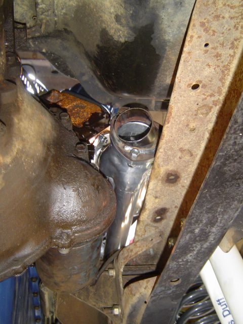 1978 Ford Bronco - New exhaust pipe section installed on an older vehicle's exhaust system, showing part of the transmission.