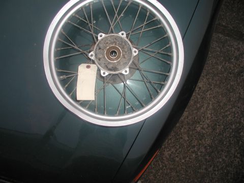 2001 Kawasaki KL650-A18 KLR650 - Spoked motorcycle wheel with a blank tag, resting on a dark surface.