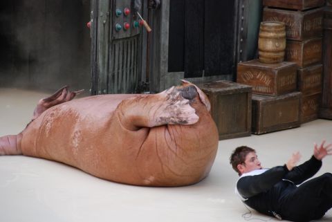 1996 Ford Bronco - A walrus lies on its side while a performer in a black suit sits on the floor nearby.