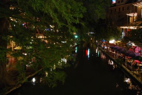 1996 Ford Bronco - A nighttime view of a riverwalk with illuminated trees and restaurants lining the water.