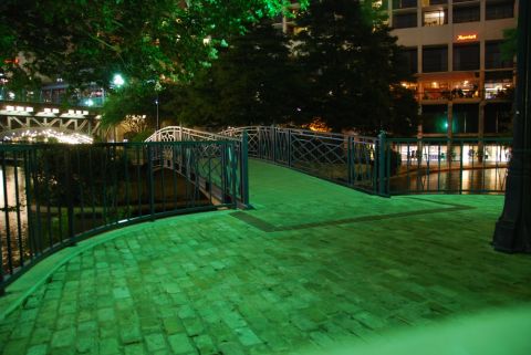 1996 Ford Bronco - A nighttime scene of a bridge and river, illuminated by green lights, with buildings visible in the distance.