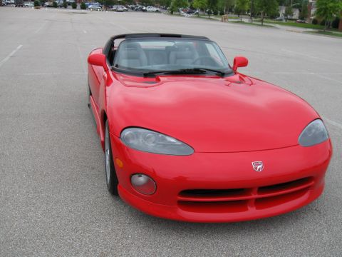 1994 Ford Bronco - This red convertible sports car features a distinctive front grille and a snake emblem, likely a Dodge Viper from the mid-1990s.