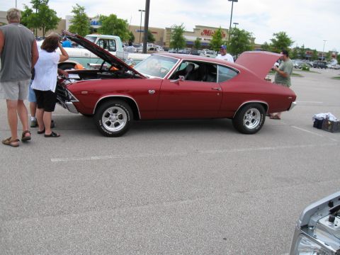 1994 Ford Bronco - A red 1969 Chevrolet Chevelle SS coupe is displayed with its hood and trunk open at a car show.