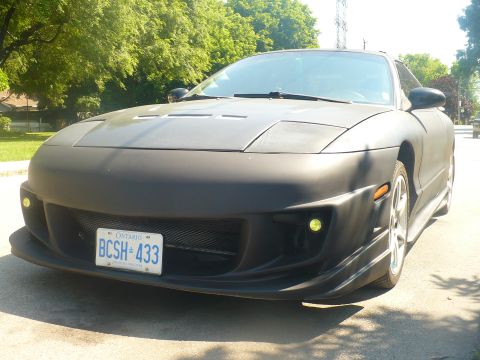 1993 Ford Probe - Matte black 1993 Ford Probe with custom body kit and yellow fog lights.