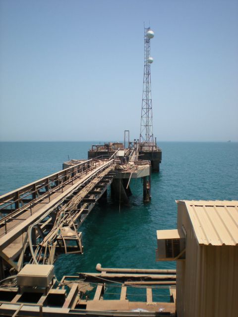 1981 Kenworth W900A - A wide view of an industrial pier extending into the ocean, a communication tower and a complex network of structures.