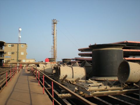 1981 Kenworth W900A - A view of industrial equipment and structures, including towers and large cylindrical components, under a clear blue sky.