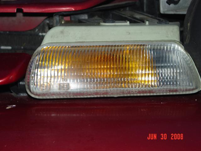 Close-up of a clear and amber car turn signal assembly with ribbed lens