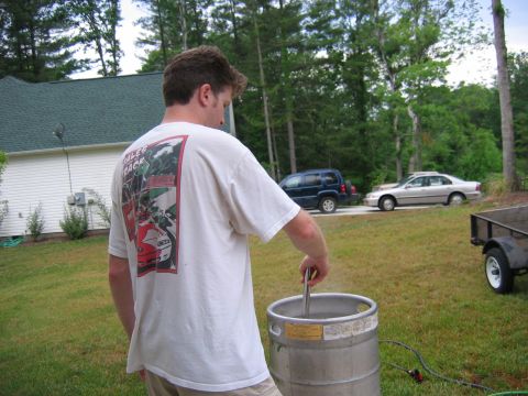 1985 Ford LTD Crown Victoria - A man is brewing beer in a backyard with two vehicles visible in the background.