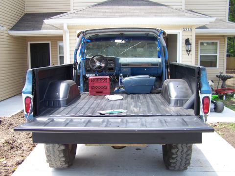 1975 Chevrolet Blazer - Rear view of a blue pickup truck, revealing its interior and bed with a red milk crate inside.