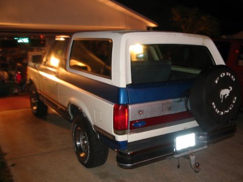 1991 Ford Bronco - This 1991 Ford Bronco is parked in a driveway at night, showing its rear and side profile.