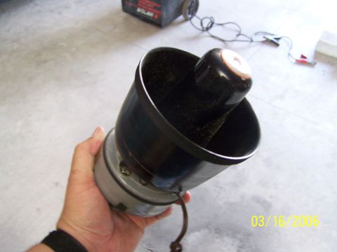 1998 Ford Crown Victoria - A car horn is held in a hand, with a battery charger visible in the background.