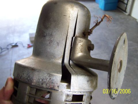 1998 Ford Crown Victoria - Close-up of a damaged metal siren, showing cracks and exposed wires, with a mounting bracket.