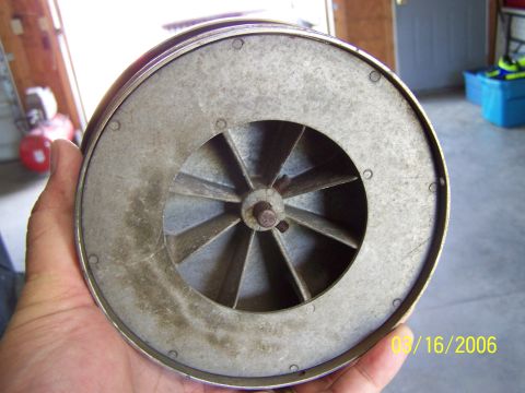 1998 Ford Crown Victoria - A blower fan part is held in a hand, with a date stamp visible on the right side.