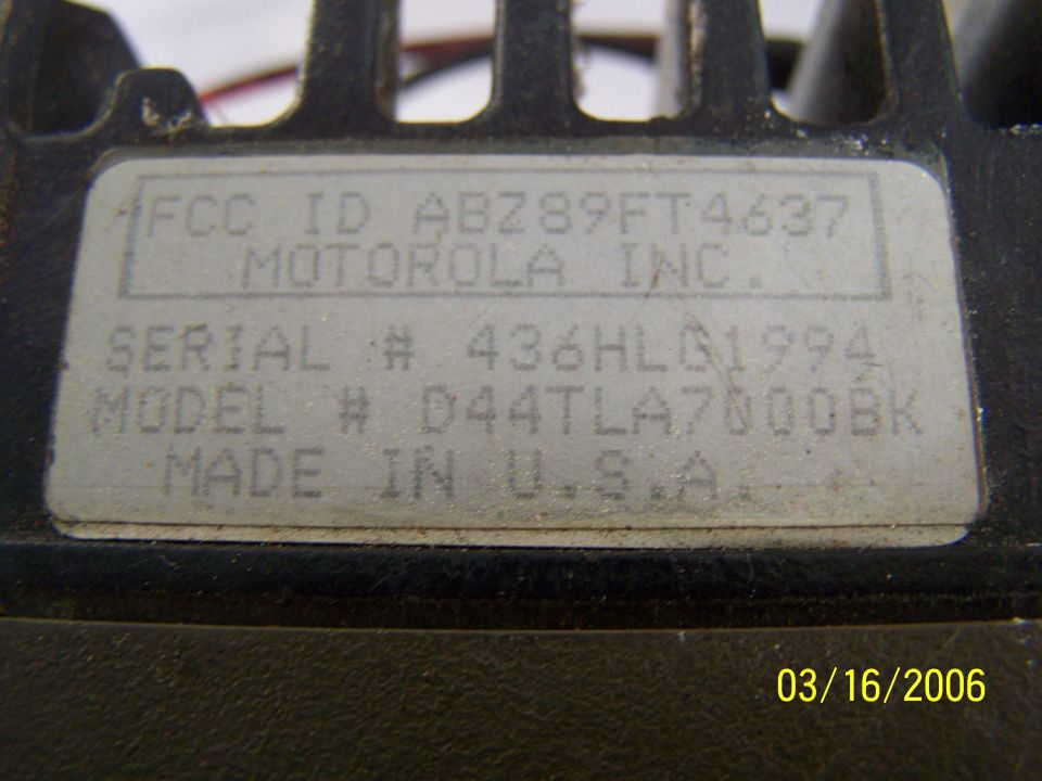Close-up of a label on a Motorola device showing FCC ID, serial number, and model number