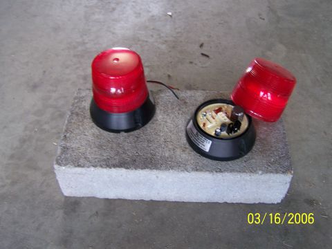 1998 Ford Crown Victoria - Disassembled red emergency lights sit on a concrete block, with a date stamp of 03/16/2006.