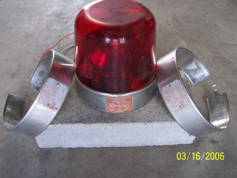 1998 Ford Crown Victoria - A red emergency light sits on concrete blocks with two chrome rings. The date 03/16/2006 is visible.