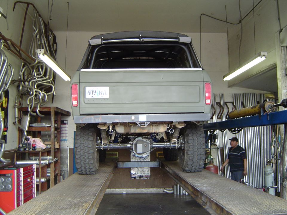 Rear view of a 1978 Ford Bronco on a lift, showing dual exhaust pipes