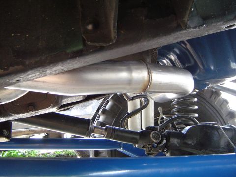 1978 Ford Bronco - Close-up of the undercarriage reveals the exhaust system and suspension components of a vehicle.