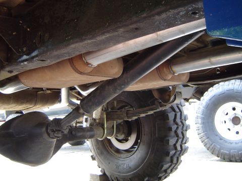 1978 Ford Bronco - Close-up view of the undercarriage of a 1978 Ford Bronco, highlighting its dual exhaust system and leaf spring suspension.