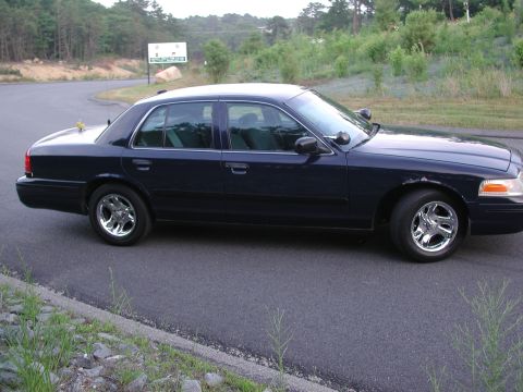 1999 Ford Crown Victoria - Side profile of a dark blue 1998 Ford Crown Victoria parked on the side of a road.
