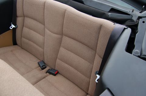 2001 Ford Crown Victoria - The interior rear seat features brown fabric upholstery and black seatbelts.