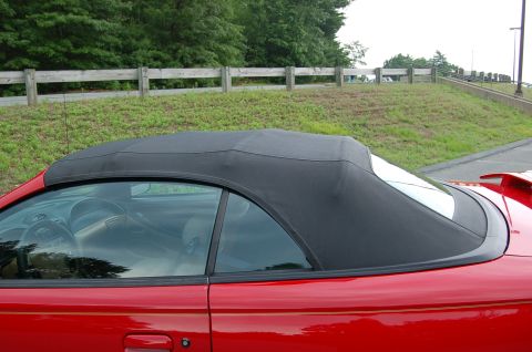 2001 Ford Crown Victoria - Side view of a red convertible with its black top up. The interior is visible through the side window.