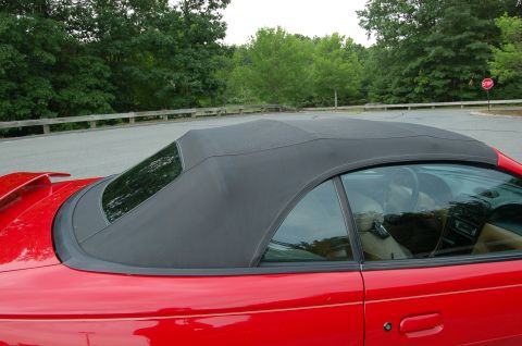 2001 Ford Crown Victoria - Side view of a red convertible with its black top up. Interior details are visible.