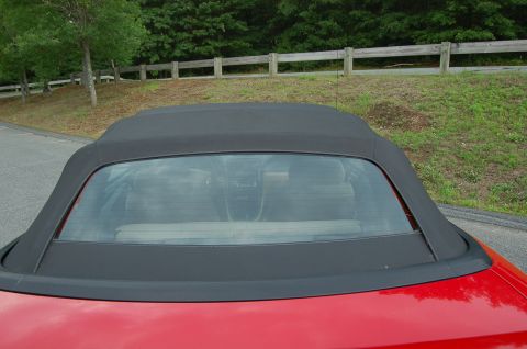 2001 Ford Crown Victoria - The rear of a red convertible is shown with its black top up, obscuring most of the vehicle.