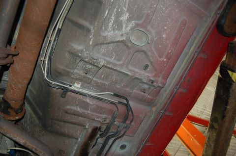 2001 Ford Crown Victoria - The undercarriage of a vehicle is visible, with various lines and components attached to the frame.