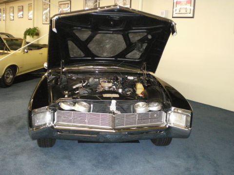 1998 Ford Crown Victoria - Black luxury coupe displayed with its hood raised, revealing the engine bay and hidden stacked headlights.