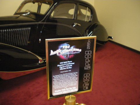 1998 Ford Crown Victoria - Museum placard for a 1932 Rolls-Royce Phantom II Continental displayed beside the black prewar sedan it describes.