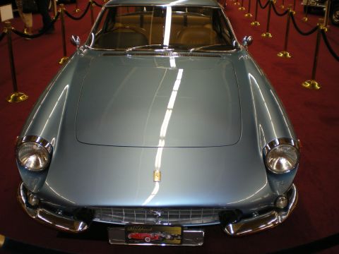 1998 Ford Crown Victoria - Light blue Ferrari coupe seen head-on, showing chrome bumpers and the prancing-horse badge on its grille.