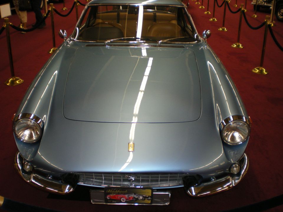 Front view of a light blue Ferrari coupe with chrome bumpers and prancing-horse grille badge