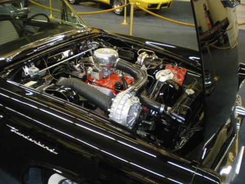 1998 Ford Crown Victoria - Detailed engine bay of a black 1950s Thunderbird showing a chrome-topped V8 with red block in a museum display.