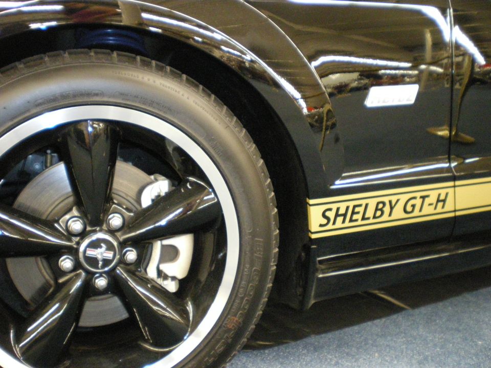 Close-up of black Shelby GT-H wheel and yellow rocker stripe reading SHELBY GT-H