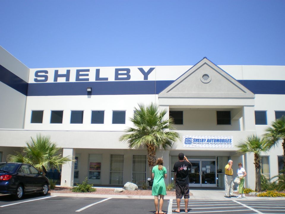Shelby Automobiles World Headquarters building exterior with palms and people outside