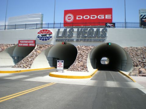 1998 Ford Crown Victoria - pedestrian and vehicle tunnels into the infield at Las Vegas Motor Speedway, with a red Dodge billboard overhead.