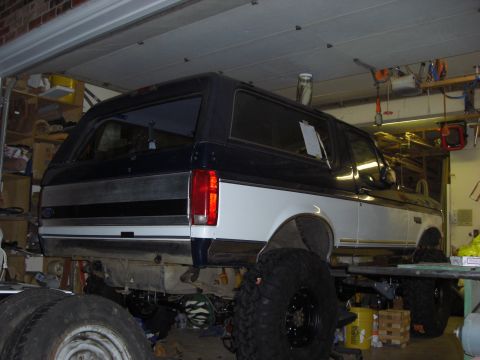 1993 Ford Bronco - This 1993 Ford Bronco is elevated on a garage lift, revealing its undercarriage and oversized wheels.
