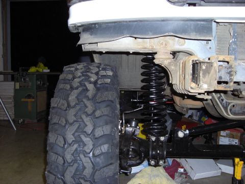 1993 Ford Bronco - Custom suspension parts are installed on a vehicle, a large off-road tire.