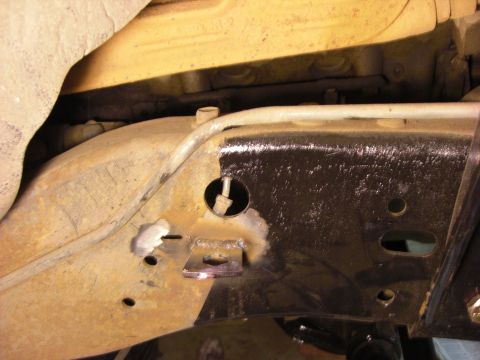 1993 Ford Bronco - Detail of a vehicle's undercarriage, showing frame modifications and suspension parts.