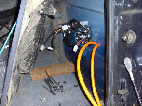1993 Ford Bronco - Close-up of an air compressor installation within a vehicle's interior.