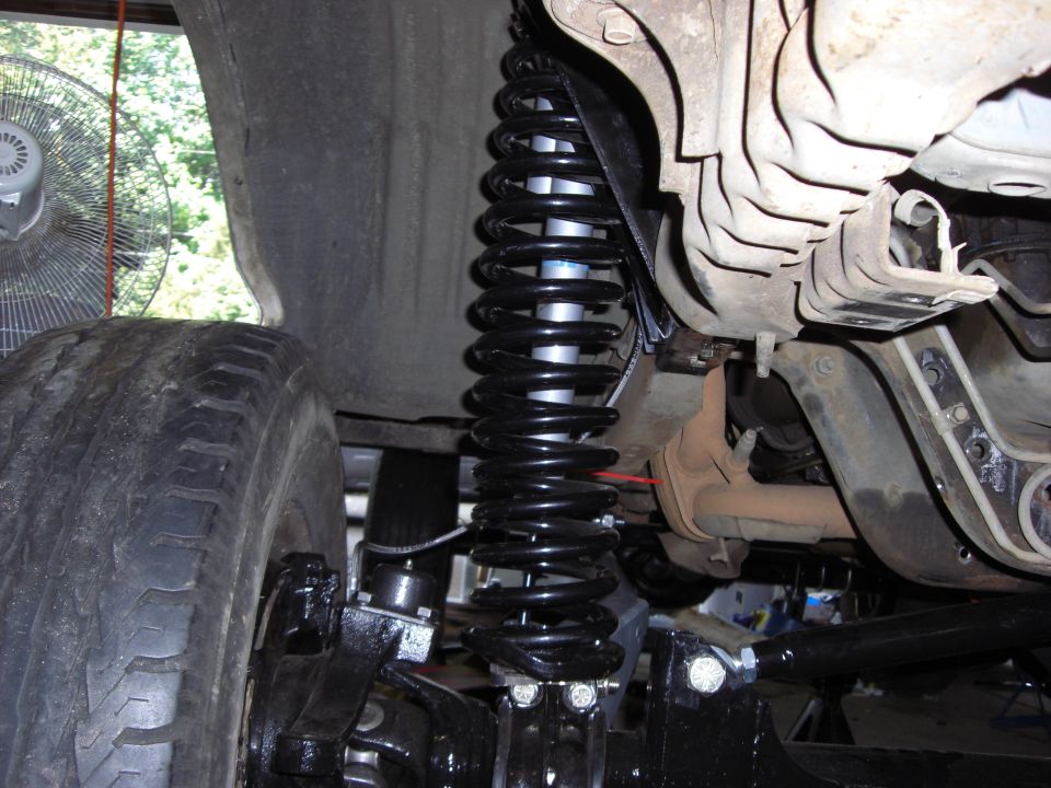 Close-up of a large coil spring and shock absorber on a vehicle's suspension