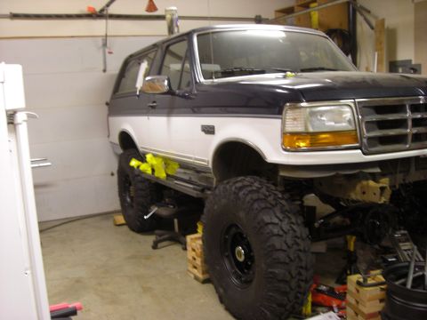 1993 Ford Bronco - This modified 1993 Ford Bronco features an extreme lift and oversized tires, suggesting custom off-road modifications.