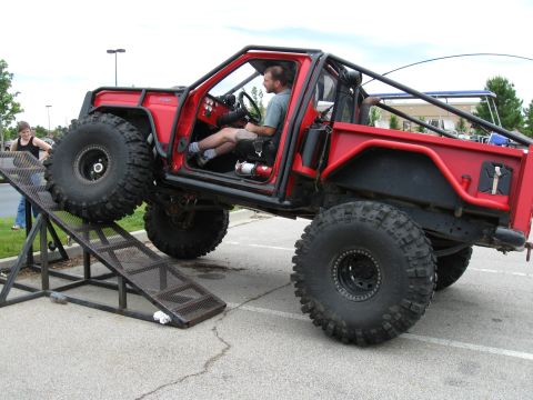 1994 Ford Bronco - A heavily modified red off-road vehicle is positioned on a metal ramp.