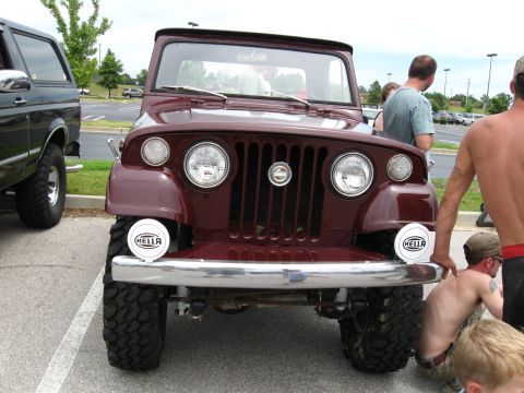 1994 Ford Bronco - A group of people gather around a vintage Jeep CJ-5 at an outdoor event.