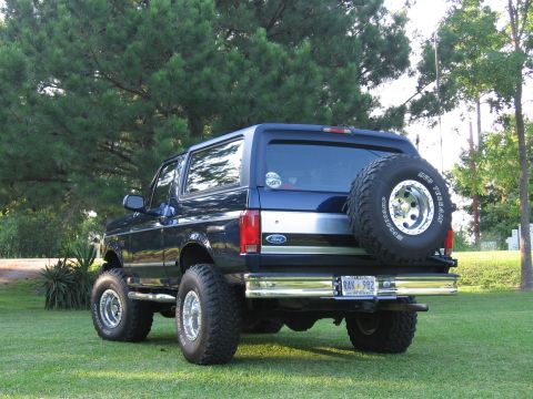 1967 Ford Mustang - Rear view of a dark blue Ford Bronco, a spare tire mounted on the back and a license plate reading RAK 982.
