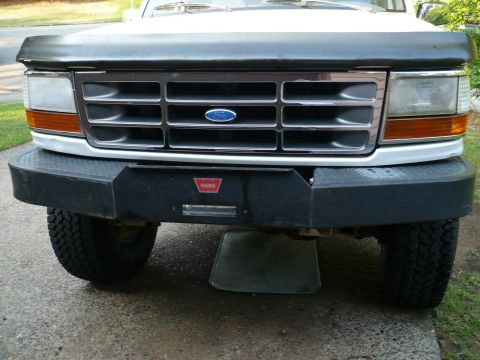 1992 Ford Bronco - The front grille and bumper of a Ford truck are shown, with a WARN logo visible on the bumper.