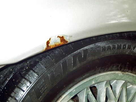 1989 Ford Thunderbird - Rust is visible in the wheel well above a tire that has 'HARMONY' written on its sidewall.