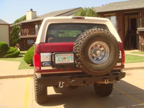 1992 Ford Bronco - The rear of a 1992 Ford Bronco shows a spare tire, aftermarket bumper, and Oklahoma license plate.