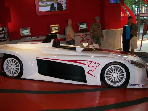 2008 Citroen Xantia - A white sports car with red racing stripes and a jaguar graphic is displayed indoors.